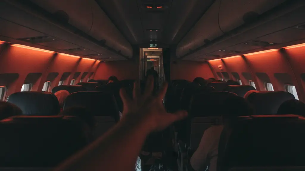 Blurred silhouette of a flight attendant's hand in a chaotic airplane cabin.