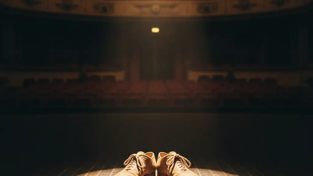 Empty stage with a single spotlight on a pair of well-worn ballroom dance shoes.