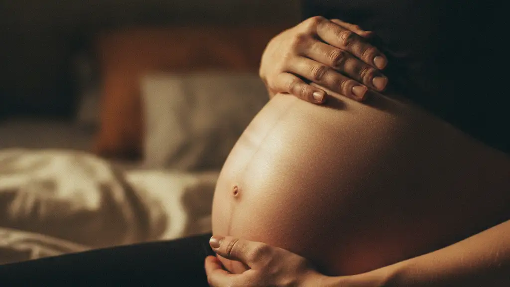 Woman's hands gently cradling a pregnant belly, soft light, intimate moment.
