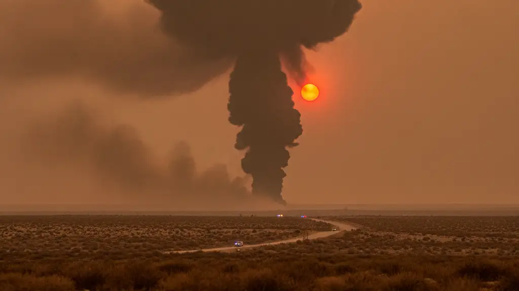 Distant smoke plume against an orange sky, with faint emergency lights in the foreground.