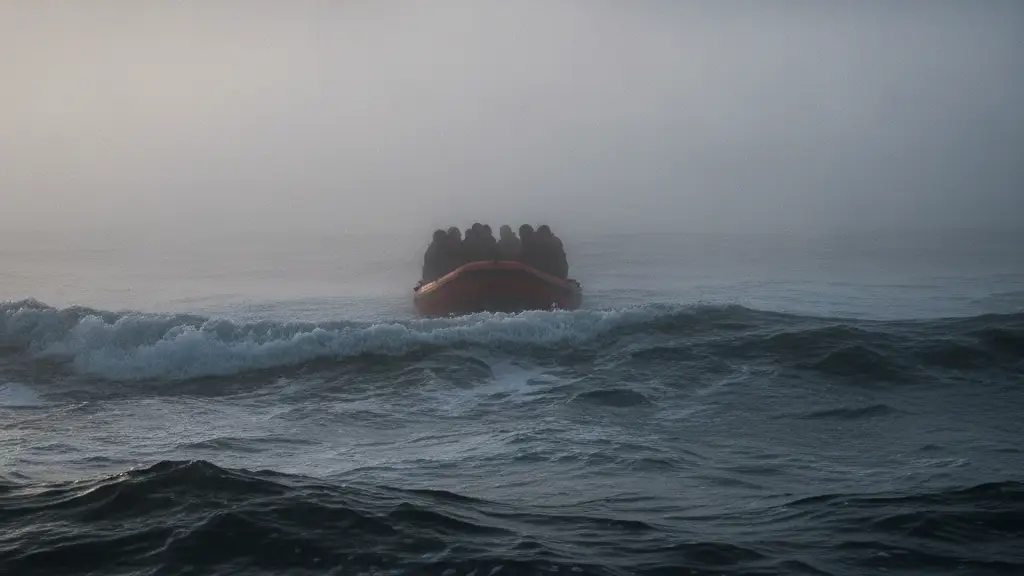 Small boat with silhouetted figures emerging from dense sea fog at dawn.
