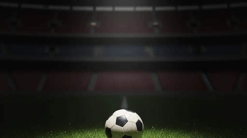 A single football on a stadium pitch under a spotlight.