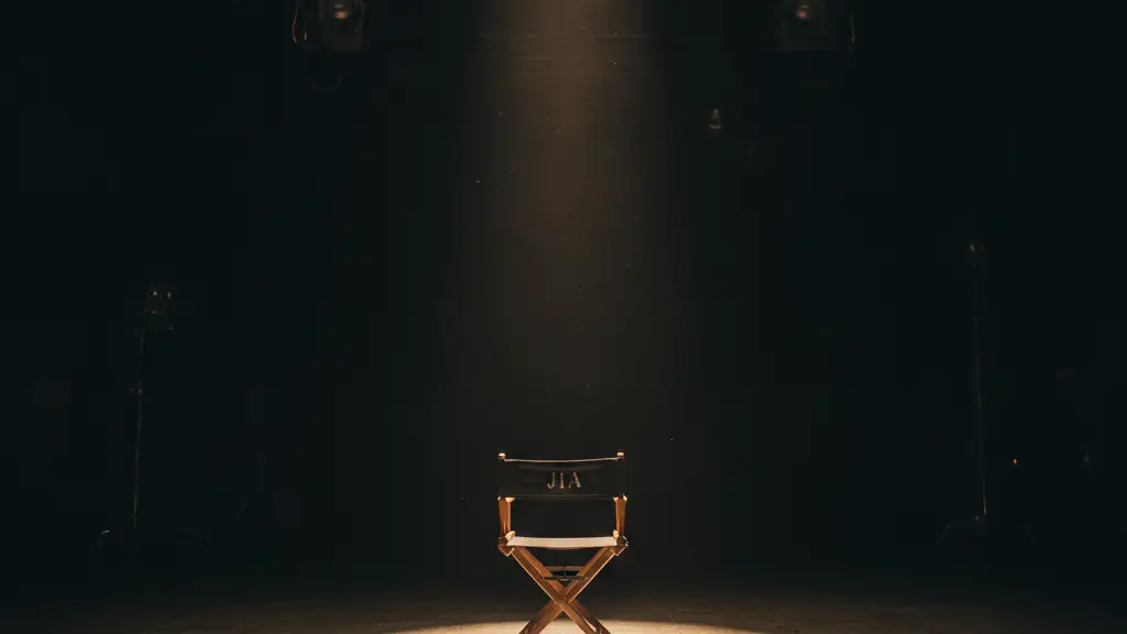 Empty director's chair with 'JIA' under a single spotlight on a dark stage.