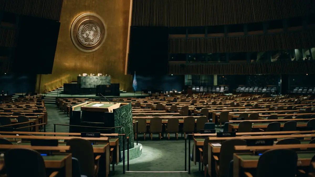 An empty, spotlighted podium at the United Nations General Assembly during a high-stakes session.