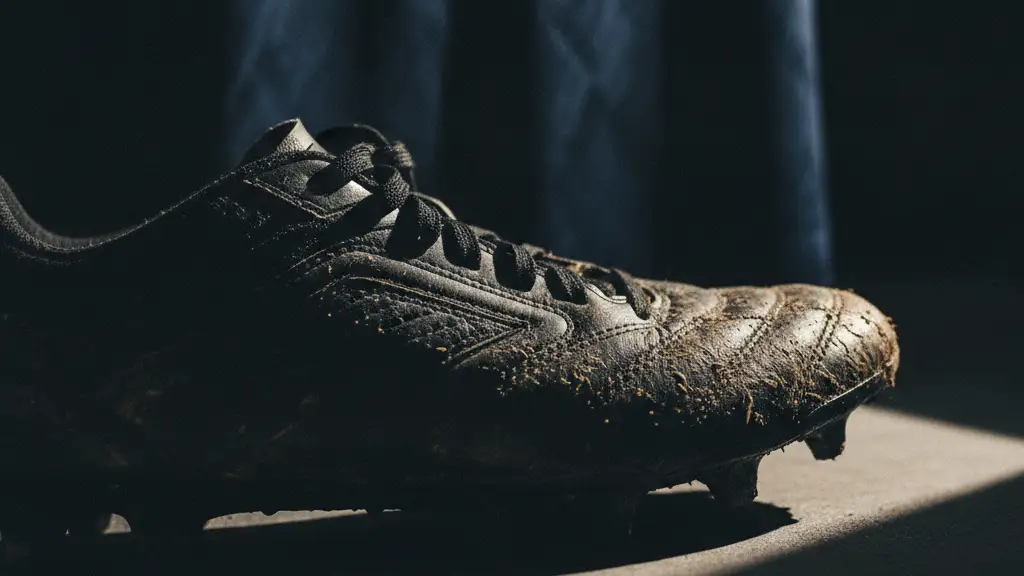 Close-up of a football boot with a blurred new jersey in the background.