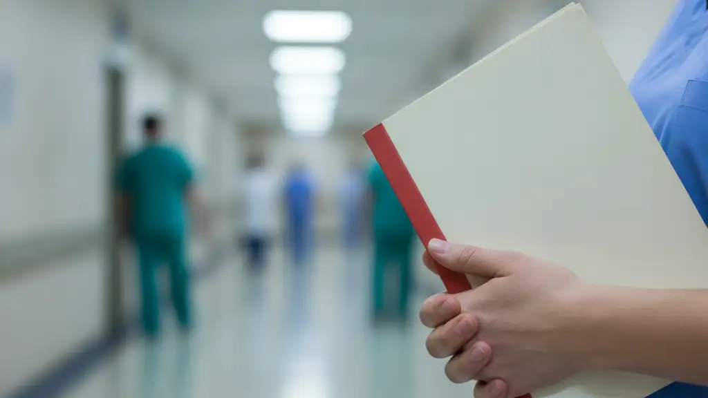 Blurred hospital corridor with hands holding a medical file, suggesting a health event.