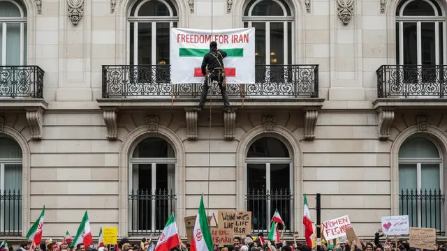 A protester climbs the exterior wall of the Iranian Embassy building in London.